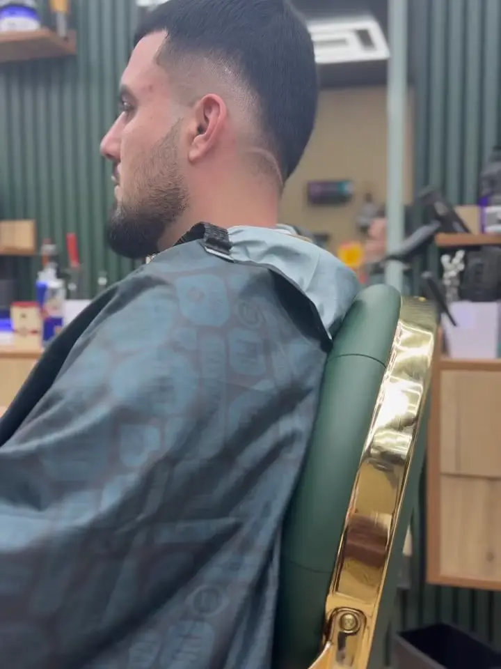 Skin fade with a shaved line design and tidy beard
