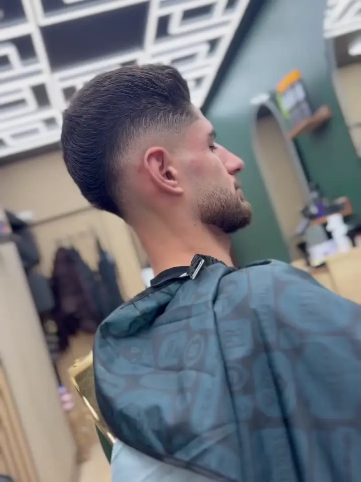 Low fade and swept-back top, side profile in the chair